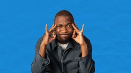 A black man with his hands on his head.